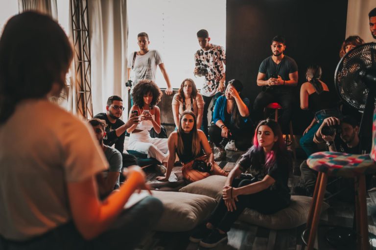 group-of-multiethnic-people-gathering-around-female-speaker-in-studio